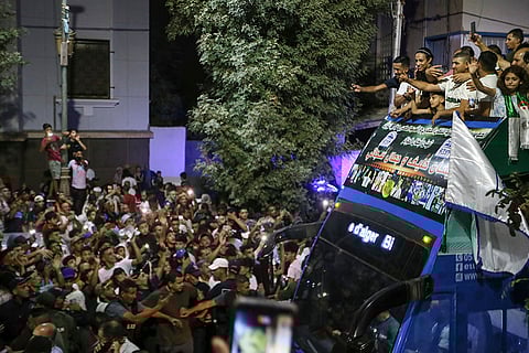 Olympic gold medalist boxer Imane Khelif waves from the top of a double decker bus